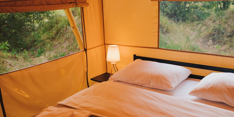 interior-cozy-open-glamping-tent-with-light-inside-dusk-luxury-camping-tent-outdoor-summer-holiday-vacation-lifestyle-concept